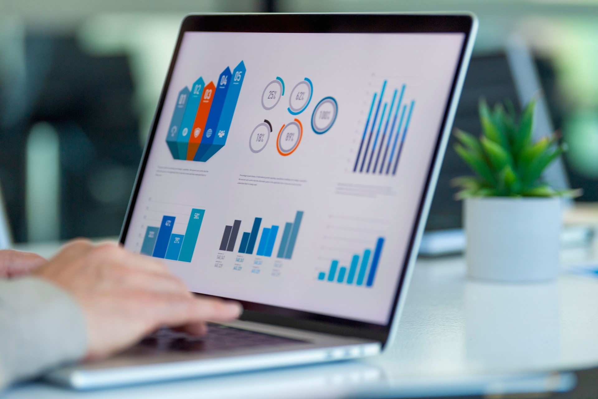 Close up of businessman using a laptop with graphs and charts on a laptop computer.